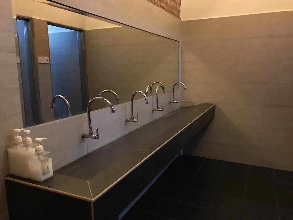 Tardaba mucho en un baño público, fueron a verlo y estaba robando las canillas